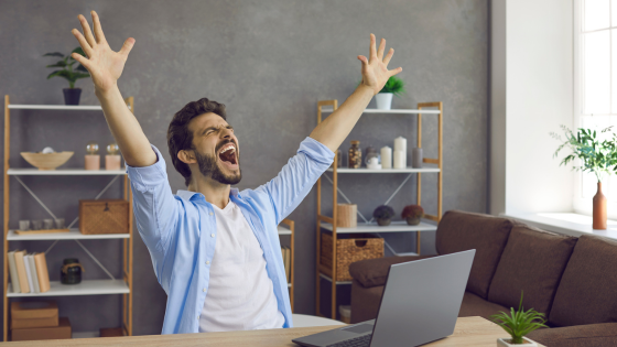 Man playing online slots cheering after winning the jackpot